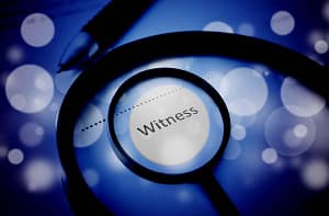 A magnifier on top of the word witness - forensic expert witness