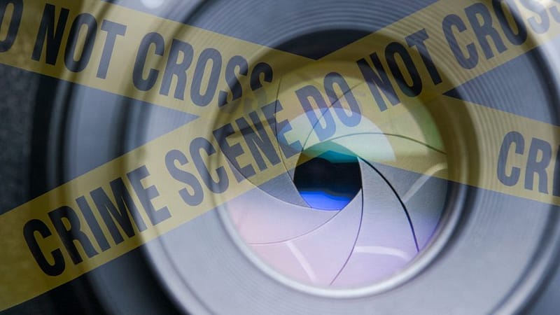 A camera aperture behind yellow crime scene tape - Pinnacle Forensics